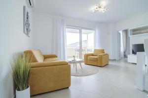 塞尼Apartments Luka - Villa Sunce的客厅配有两把椅子和一张桌子