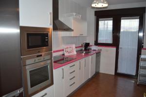 Mata de QuintanarEl Cierzo de la Mata的厨房配有白色橱柜和红色台面