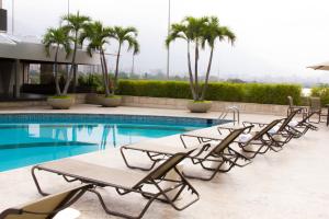 加拉加斯Hotel CCT Caracas的一组椅子坐在游泳池旁