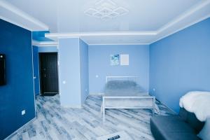 文尼察Сучасна 1-кімнатна квартира的蓝色的客房配有床和沙发