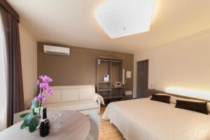 西尔米奥奈International Rooms & Apartments的一间卧室配有一张床、一张沙发和一张桌子