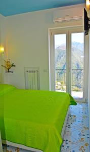 拉维罗Palazzo Mansi的一间卧室设有一张绿色的床和一个窗户。