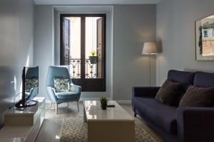 马德里Arenal Suites Puerta del Sol的客厅配有蓝色的沙发和椅子