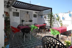 丹吉尔Dar Essaki 1886的庭院配有红色和绿色的桌椅