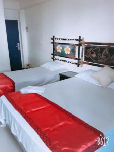 南迪Nadi Airport Transit Hotel的两张床,上面有一条红毯