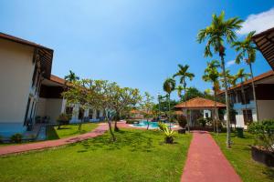莫日布Villea Morib的一个带游泳池和棕榈树的度假庭院