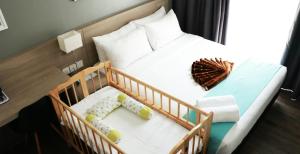克提Singgah Kertih的一间卧室配有一张婴儿床,里面有两个婴儿