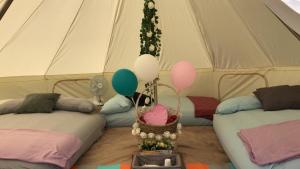 新加坡Glamping Kaki - Large Bell Tent的帐篷配有两张床和气球