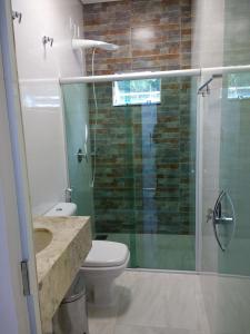 戈亚斯州上帕莱索Pousada das Cachoeiras的一间带卫生间和玻璃淋浴间的浴室