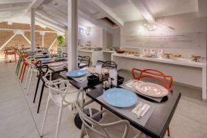 库尼奥Best Western Plus Royal Superga Hotel的一间带桌椅和柜台的用餐室