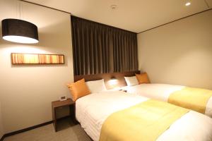 盛冈凯塔酒店的酒店客房设有两张床和窗户。