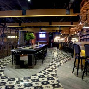 雅加达卡拉巴加丁薇姿普瑞酒店的餐厅设有酒吧,配有桌椅