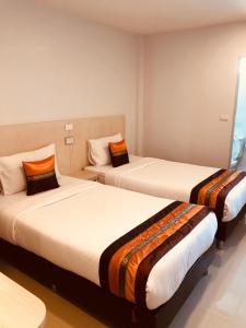 清迈Chiangmun Boutique的一间酒店客房,房间内设有两张床