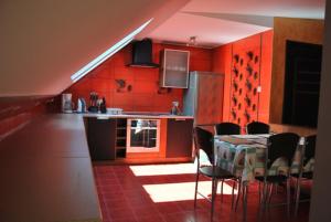 姆热日诺Nestor II的厨房设有红色的墙壁和桌椅