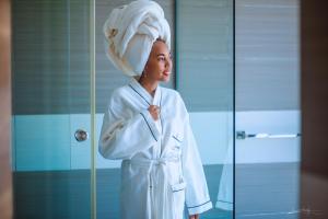 图阿马西纳The Streamliner Hotel Apartment的头上毛巾的浴袍里的女人
