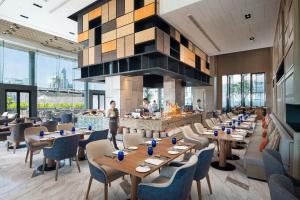曼谷曼谷日航酒店的餐厅设有木桌、椅子和壁炉
