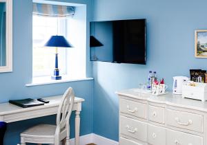 阿特尔伯勒舍伯恩酒店的蓝色的客房配有白色的办公桌和电视。