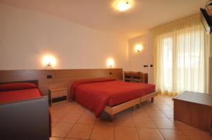 安达洛Residence Alba Nova的酒店客房配有红色的床和沙发