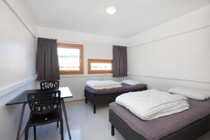 奥斯陆Anker Hostel的一间卧室配有两张床、一张桌子和一把椅子