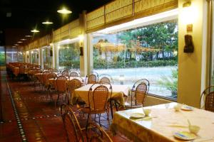 Wenquan知本泓泉温泉渡假村的一间空餐厅,配有桌椅和窗户
