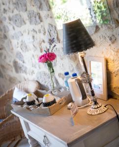 Port-Sainte-Marie拉洛奇尼尔住宿加早餐旅馆的一张桌子,上面有台灯和花瓶