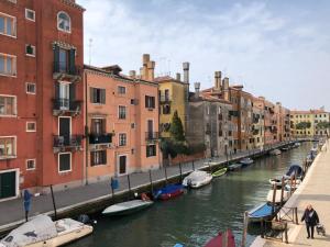 威尼斯迪吉艾弗纳克诺比莱钢琴度假屋的一条运河,在一座有建筑物的城市里划船