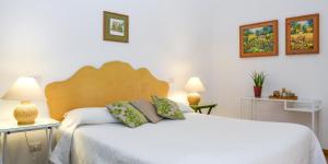 卡普阿Masseria GiòSole的卧室配有一张白色床、两张桌子和两盏灯。