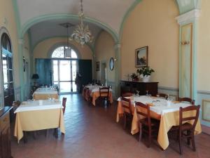 博洛尼亚Locanda Corte Roveri的一间带桌椅和吊灯的用餐室