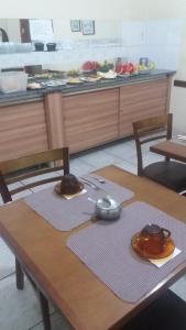 容迪亚伊Hotel Central Rosário的一张桌子、两把椅子和一个柜台,上面有食物