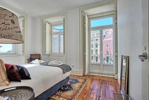 里斯本MyPlaceLisbon - Luxury Trindade III的一间卧室设有一张床和一个大窗户