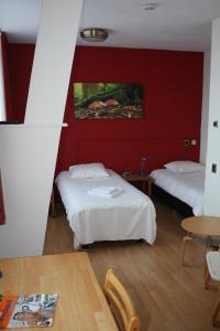 波尔代克圣文森特酒店的红色墙壁的客房内的两张床