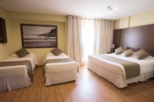 陶巴特Olavo Bilac Hotel的酒店客房设有两张床和大窗户。