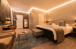 布鲁日合欢酒店的酒店客房设有一张大床和一张沙发。