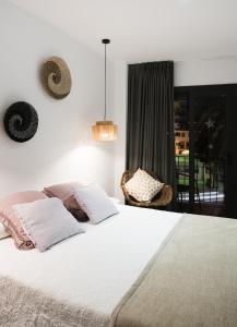布拉内斯Hostal Sa Malica的卧室设有一张白色大床和一扇窗户。