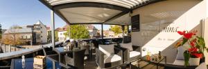 比肯费尔德Hotel -Restaurant Taormina的阳台餐厅,配有桌椅