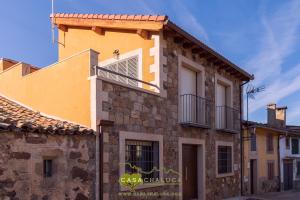 La AldehuelaCasa Chaluca的黄色的建筑,旁边设有阳台