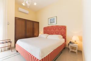 巴里Masseria Sant'Anna的一间卧室配有一张大床和红色床头板