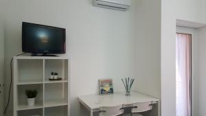 蒙扎DaNicolas Cairoli Apartment的一间客厅,在白色架子上配有电视