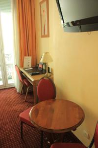 里昂富驰酒店的客房设有书桌和桌椅。