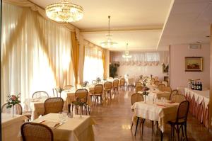 蒙特卡蒂尼泰尔梅托雷塔酒店的一间设有白色桌椅的用餐室