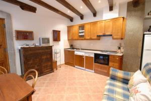 别尔萨Apartamentos Sorripas 1 hab的厨房配有木制橱柜、桌子和沙发。