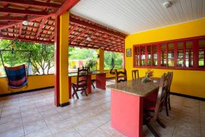 马拉塔伊济斯Pousada dos Gravatais的用餐室设有黄色的墙壁和桌椅