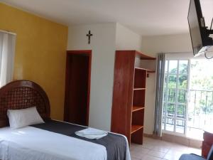 帕拉伊索DON CELES的卧室配有一张床,墙上有十字架