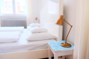 迪森阿姆阿梅尔塞茅乐哈索酒店的一张带白色床单的床和一张桌子上的台灯