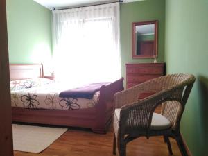 里瓦德奥El piso de Carlos的一间卧室配有一张床、一把椅子和镜子