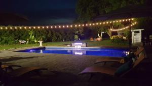 MiltonMansion Farm Inn的后院,晚上设有游泳池,灯光照亮