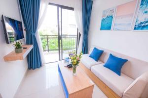 岘港Sincero Hotel & Apartment的客厅配有沙发和桌子