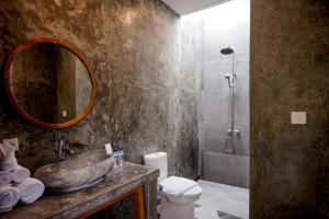 坎古La Isla Villas Bali的一间带水槽、卫生间和镜子的浴室