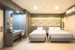 曼谷Sound@sleep Hotel的一间卧室配有两张床、一张桌子和一个水槽