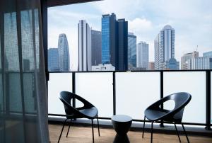 东京Oakwood Apartments Nishi-Shinjuku的城市天际线客房的两把椅子和一张桌子